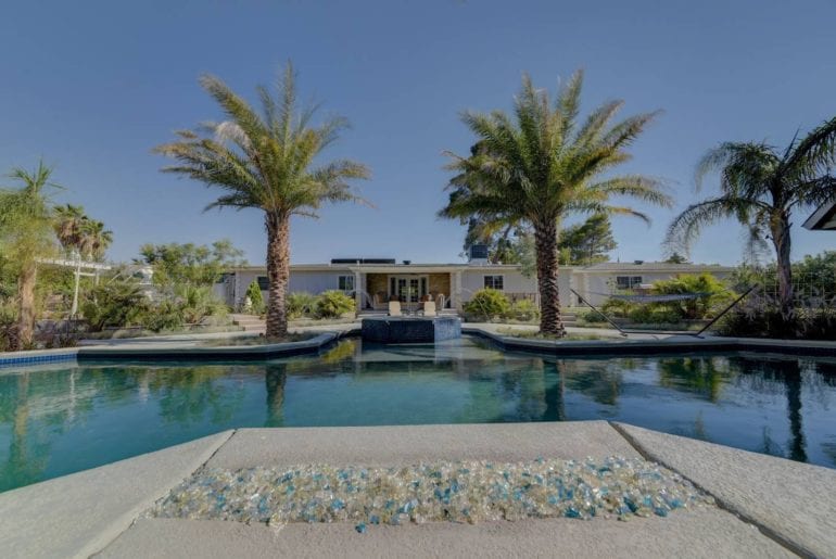 Private pool framed with palm trees, hammocks and gorgeous decor.