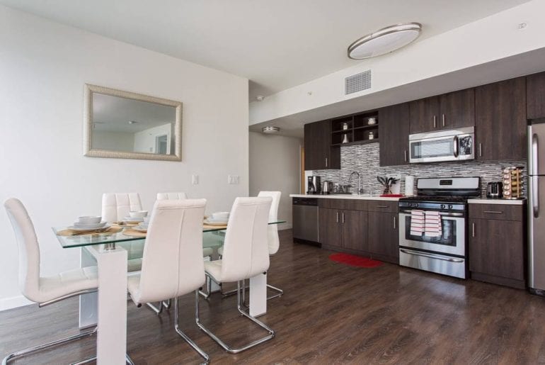 Open floor plan living space with a stocked kitchen and unique dining table 