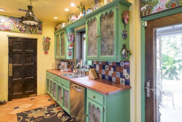 This bright kitchen has wonderfully vibrant tiling and handmade cabinet doors
