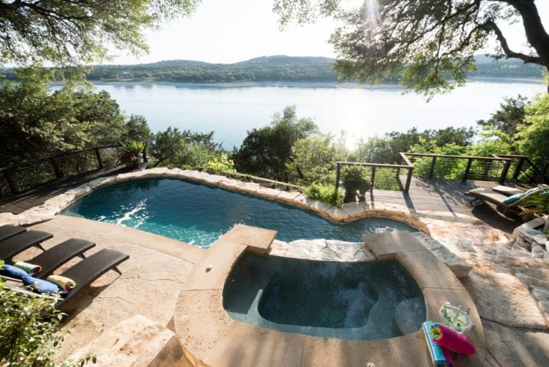 The backyard boasts breathtaking views of Lake Travis from the saltwater pool and hot tub