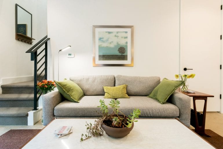 The guesthouse is complete with fresh flowers, a cozy couch and green accent pillows. Austin Hilton