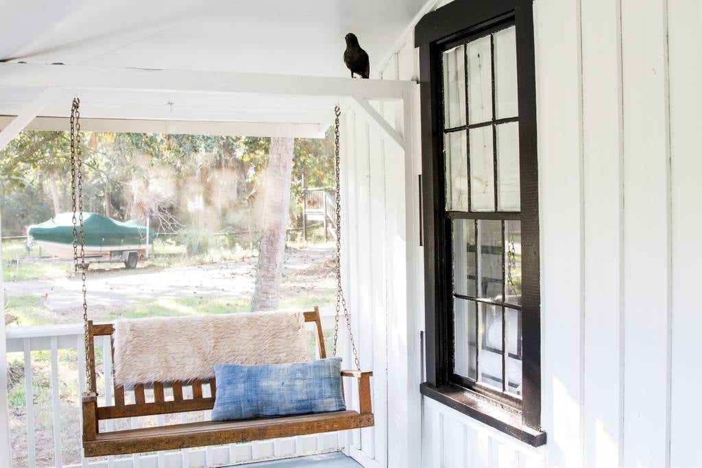 Serene swing hangs from the porch of this vintage Folly Beach cottage