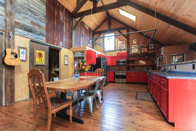 High, vaulted ceilings with a rugged, deconstructed finish in the kitchen/dining room of this refurbished barn
