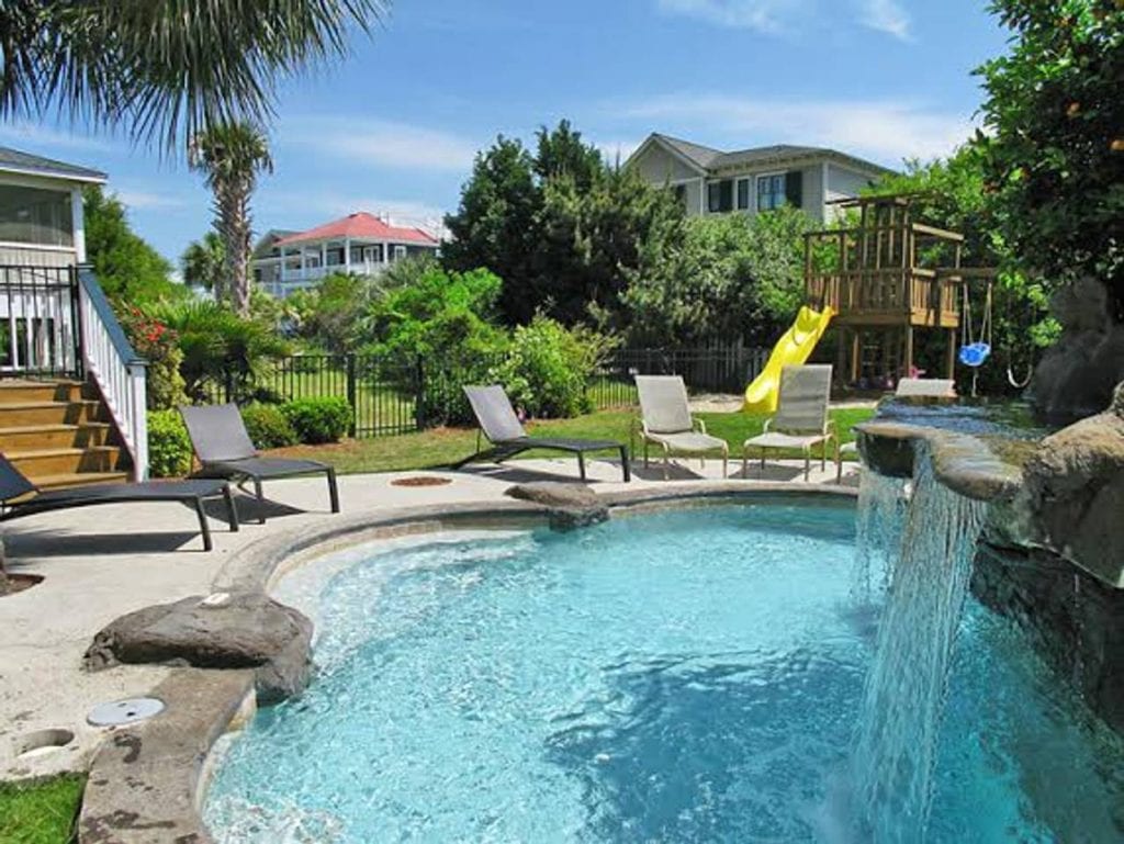 Backyard paradise for families with this private playground and in-ground pool with a waterfall feature