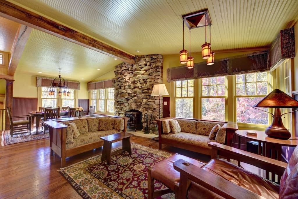 Open floor plan of a living/dining room featuring a stacked stone hearth