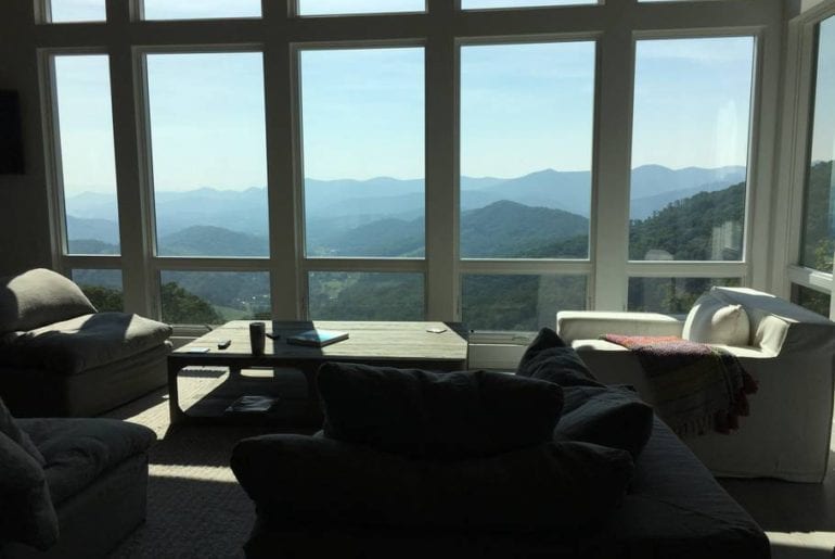 Mountain views outside of the large windows in this cozy, Asheville living room