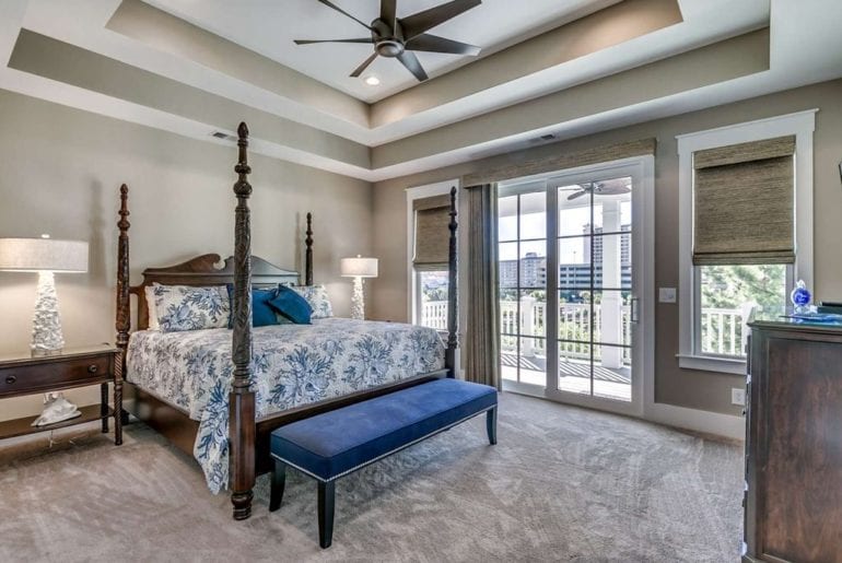 a bedroom with a fan above the bed