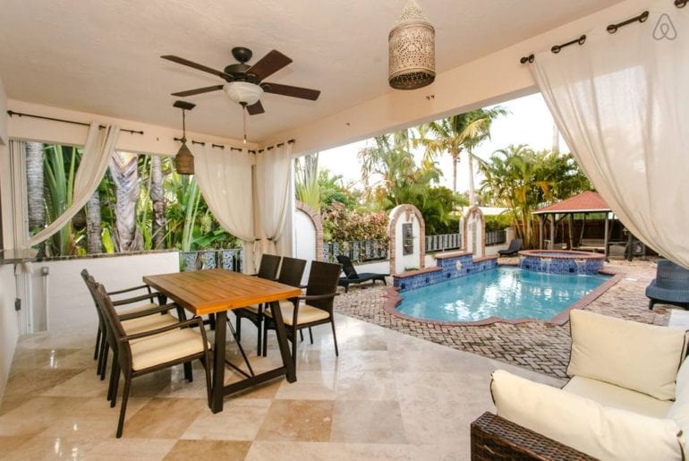 a dining area by a blue pool in West Palm Beach