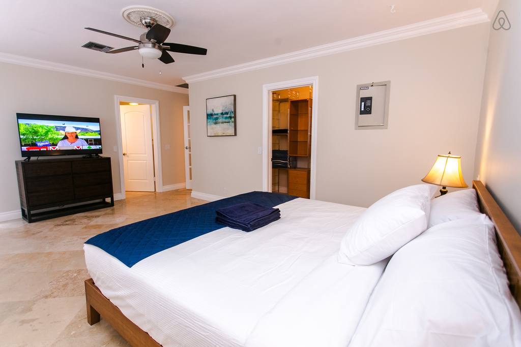 a bed with white sheets on it in an Airbnb in West Palm Beach