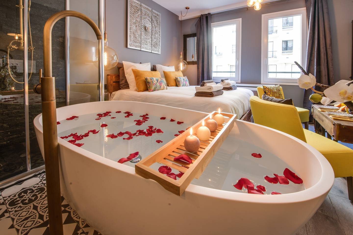 a stand alone bath tub with rose petals