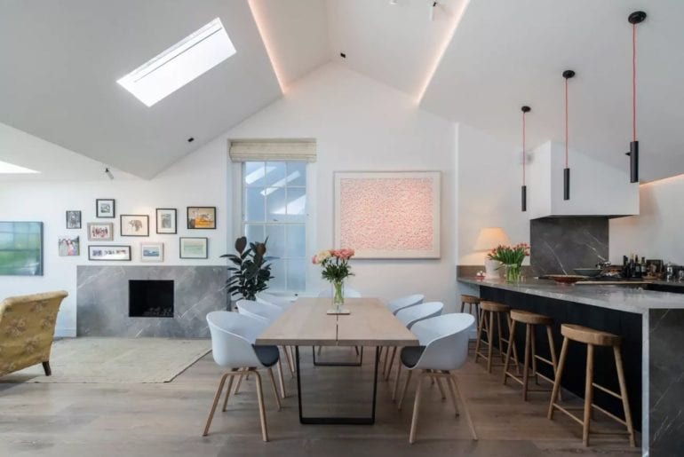 stylish London Airbnb dining room with white chairs and art on the walls
