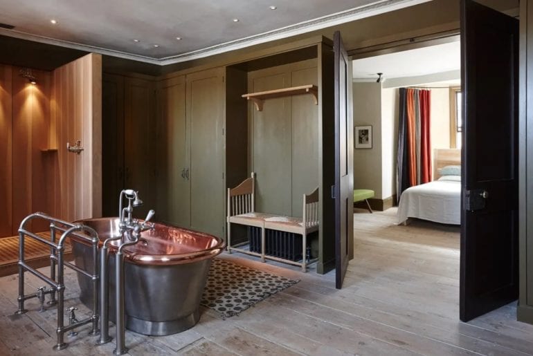 copper bath on wooden floors and green walls