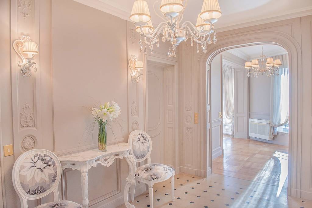 An all-white reception area with old fashioned chairs in Paris