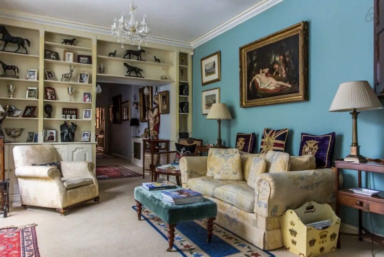a Kensington living room with a painting of a nude woman above the sofa