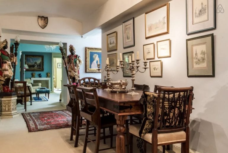 a mahogany dining table with some candlesticks on it and some statues in the background 