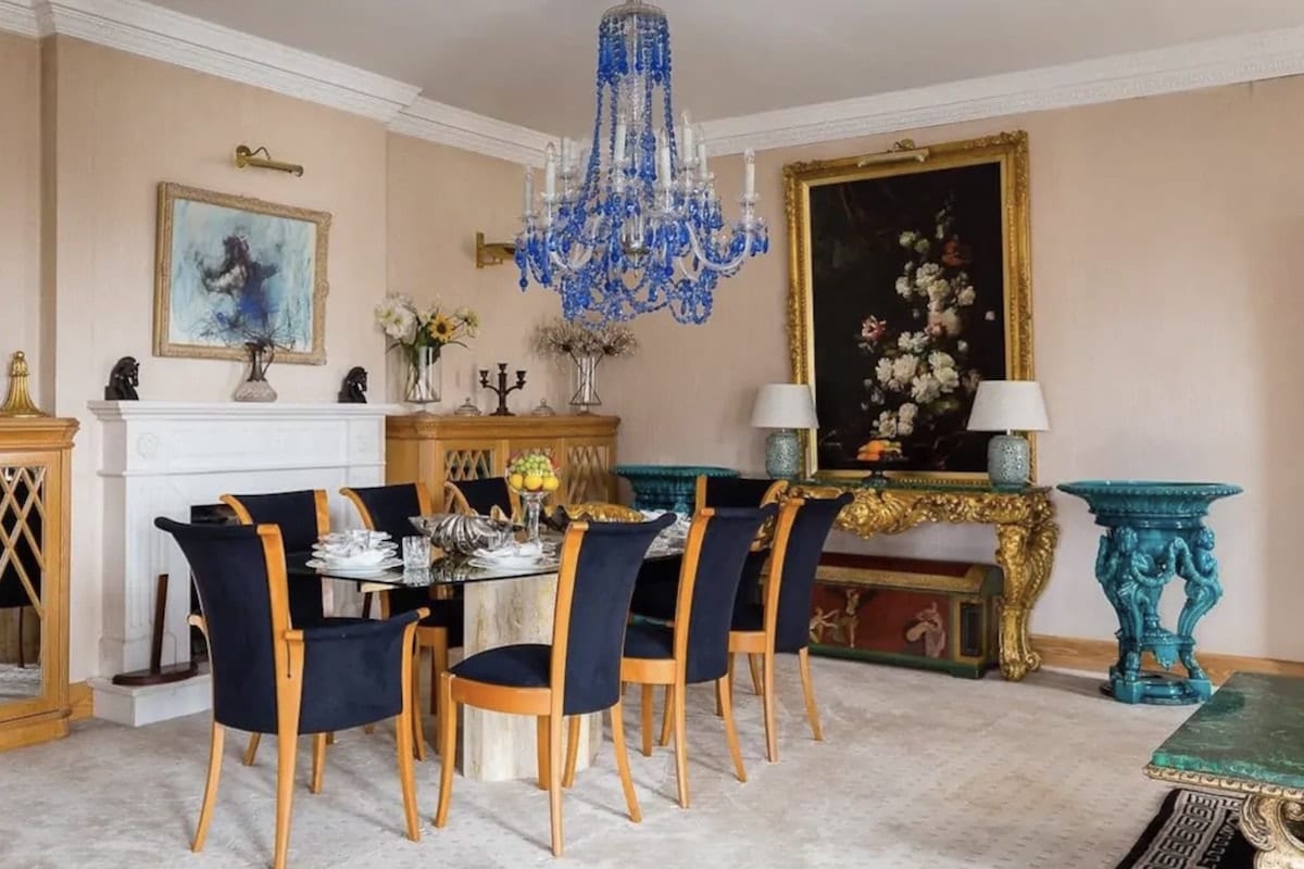 a hyde park Airbnb dining room with a chandelier and painting in the background 