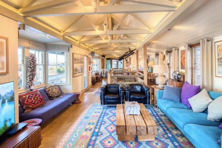 interior of houseboat on the Thames, blue sofas and wooden beams painted white