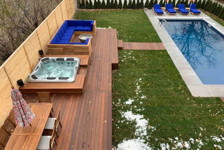 The backyard has a gorgeous seating area, hot tub, and pool